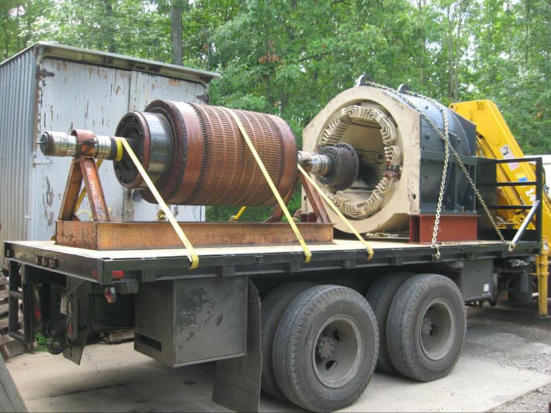 2000 KW generator strapped and chained onto a flatbed trailer.